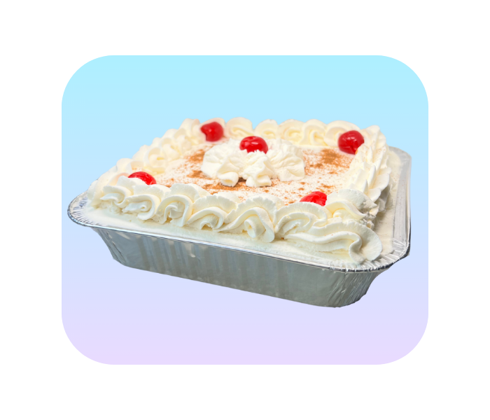 Square tres leches cake with white frosting and red cherries in a metal pan on a light blue background